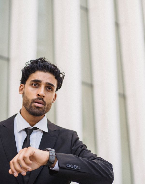 A man in a suit checking his watch